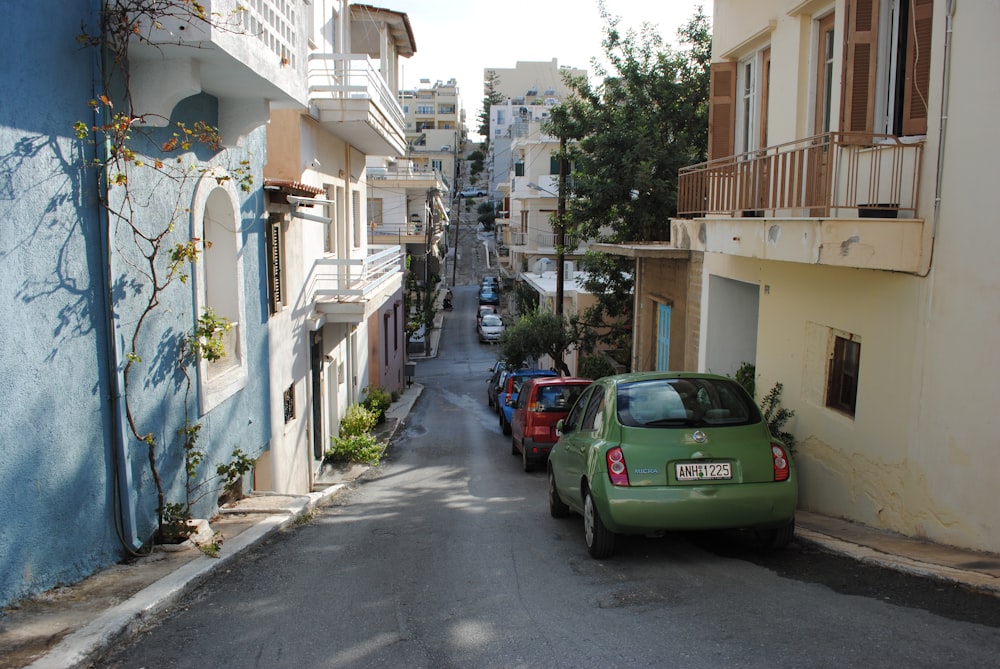 green car parked beside white concrete building during daytime