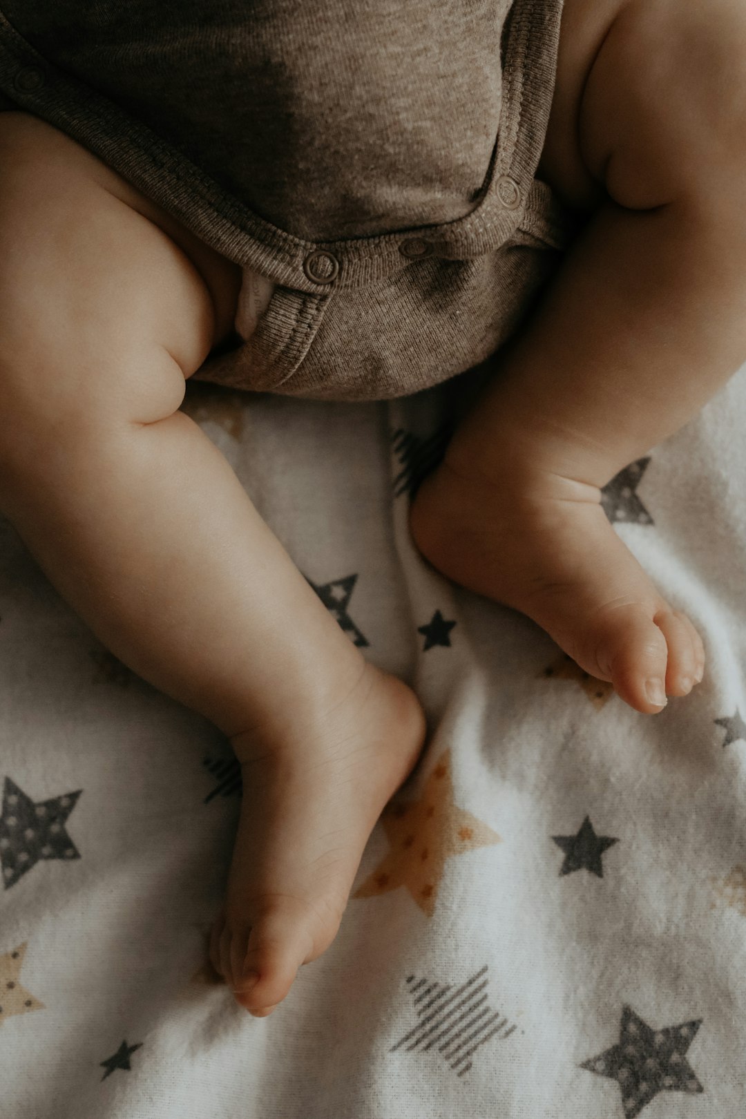 baby lying on white and black star print textile