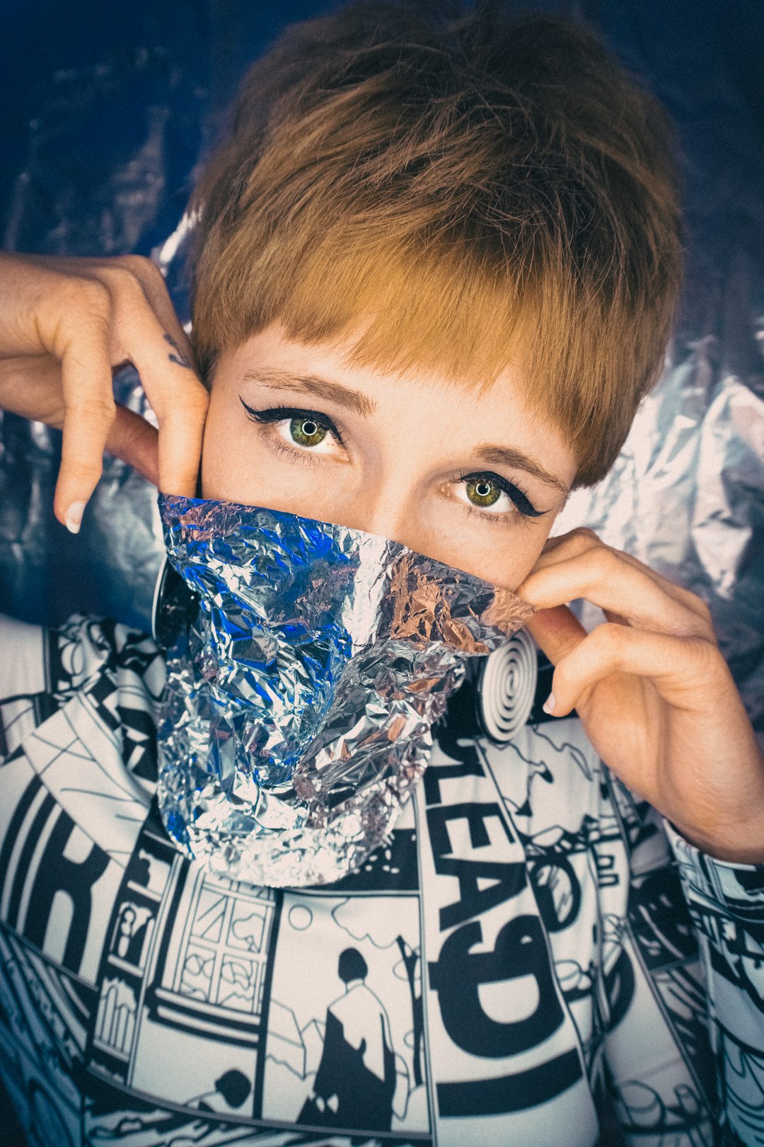 woman in black and white shirt covering her face with white and blue floral textile
