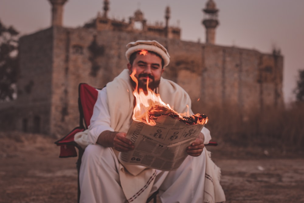 man in white thobe holding book