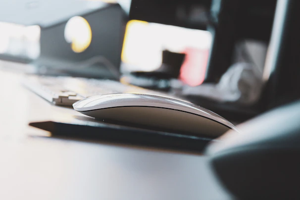 Close-up of a sleek ergonomic mouse on a wooden desk with soft natural light