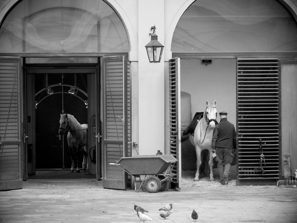 grayscale photo of man and woman walking on sidewalk