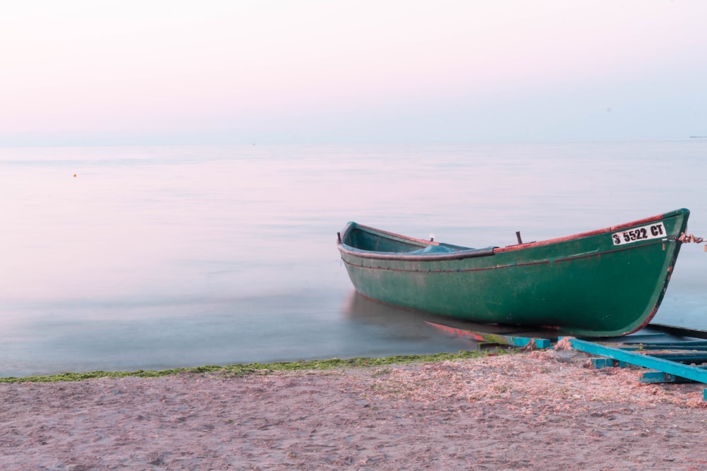 red and green boat on beach shore during daytime