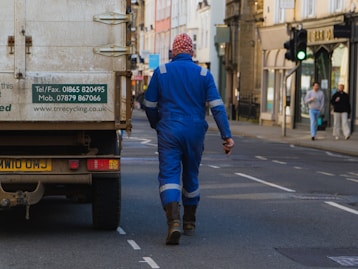 man in blue jacket walking on pedestrian lane during daytime