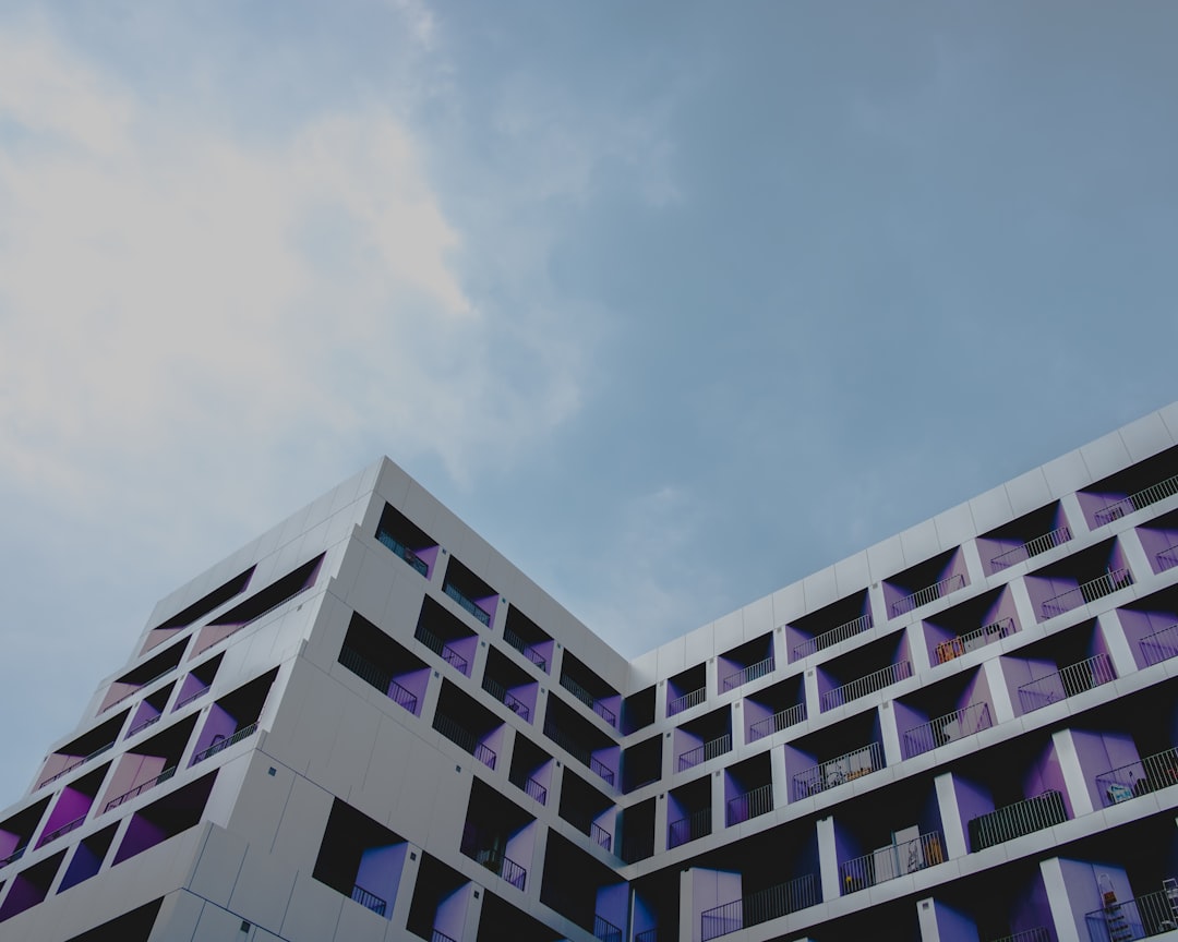 white and black concrete building under white clouds during daytime,