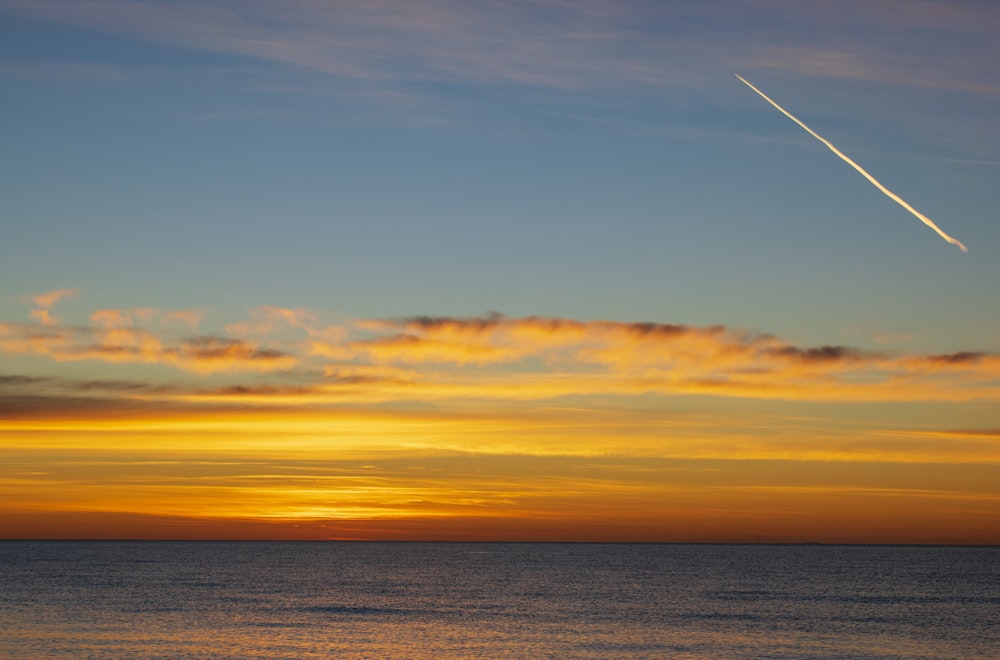 body of water under orange sky during sunset