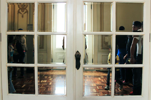 Elegant glass-paneled door reflecting a cozy interior.