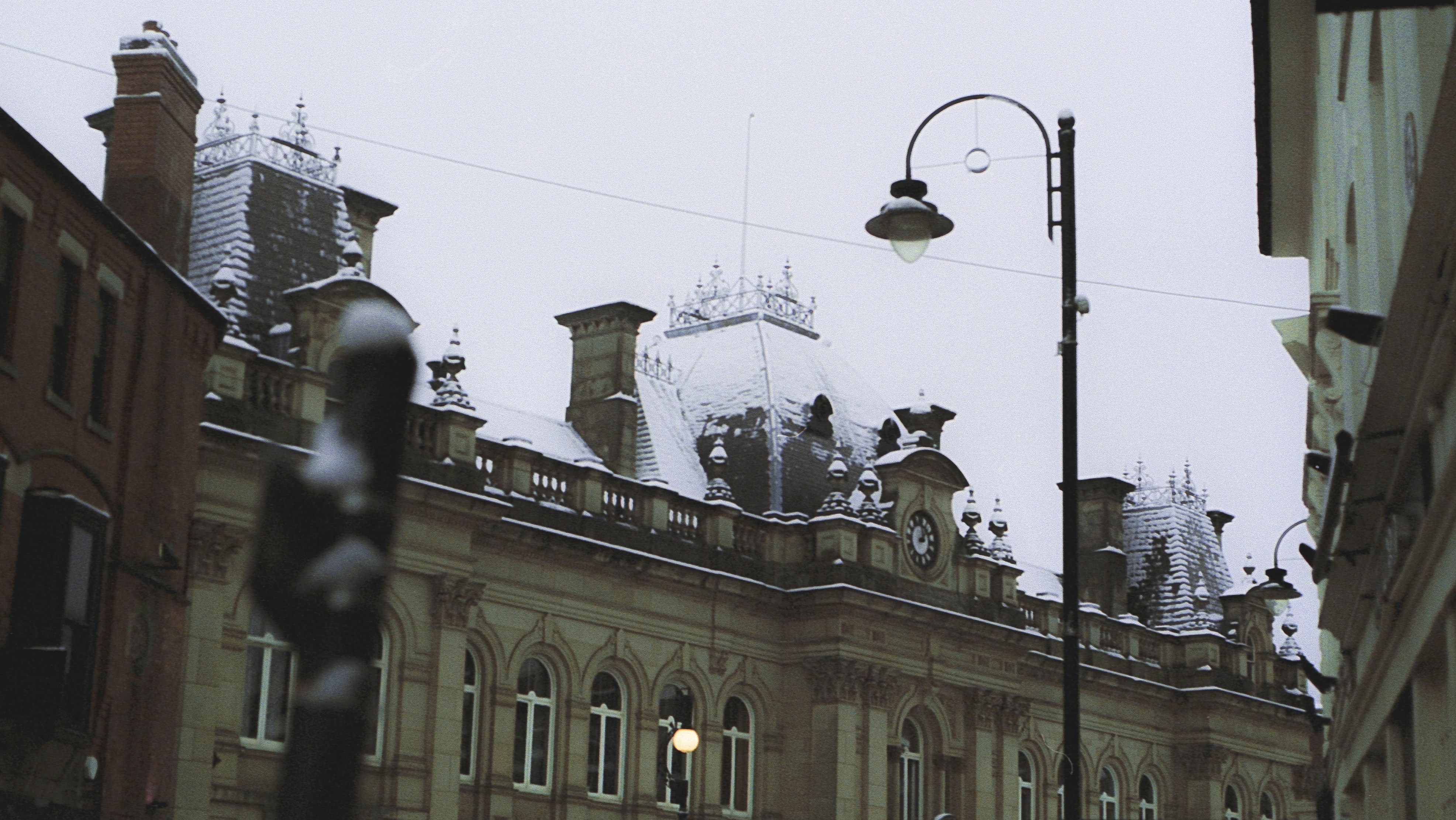 Schwarze Straßenlaterne in der Nähe eines weißen Betongebäudes tagsüber