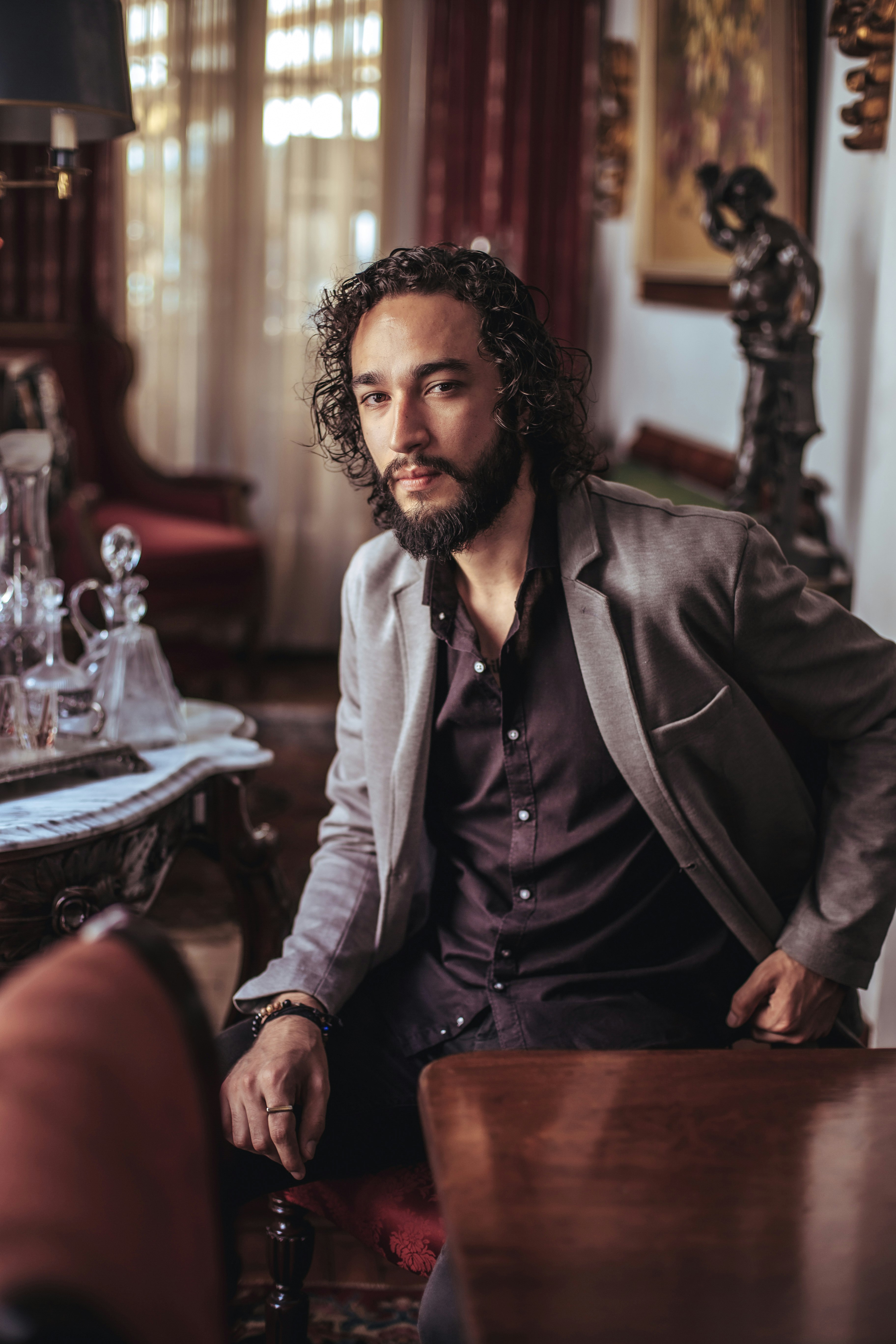 man in black suit jacket sitting on chair