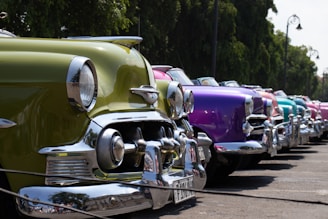 A row of colorful cars lined up under bright sunlight ready for sale