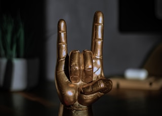 gold human figurine on brown wooden table