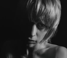 Minimalist fashion portrait with cinematic shadows and golden accents.