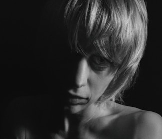 Minimalist fashion portrait with cinematic shadows and golden accents.