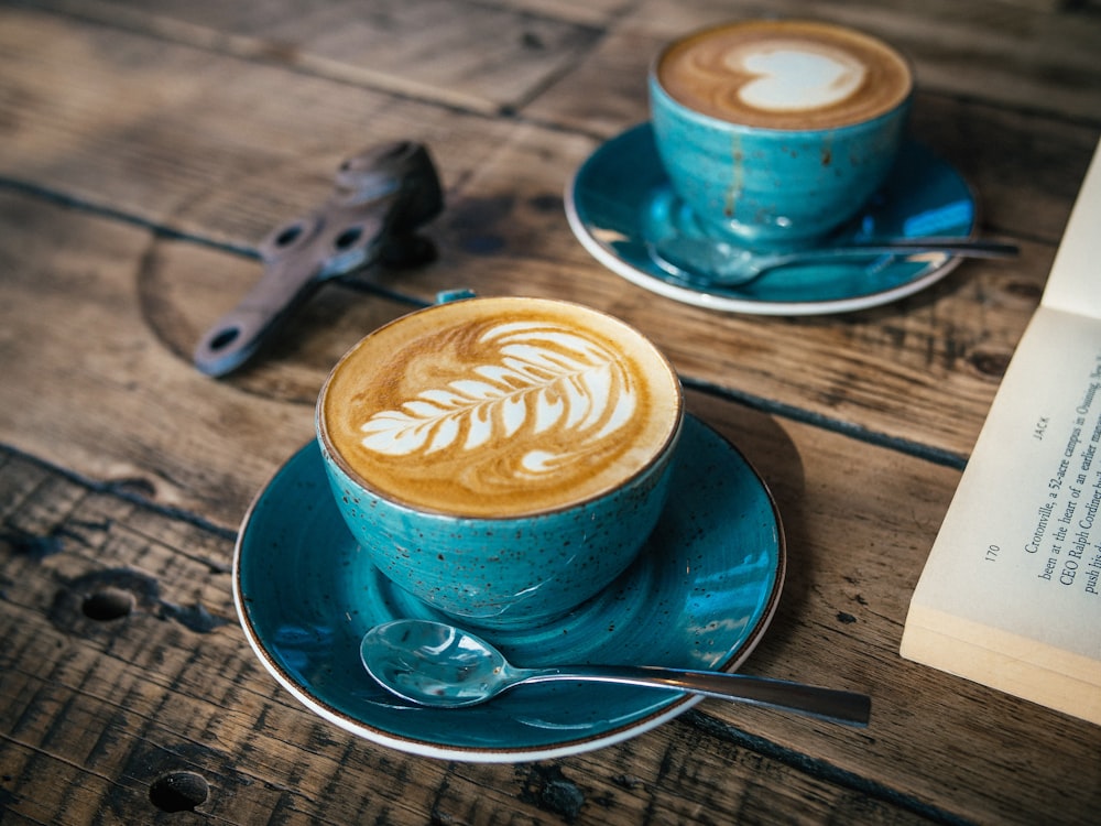 blue ceramic cup with cappuccino on blue saucer