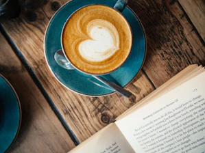 blue ceramic mug with cappuccino on blue saucer