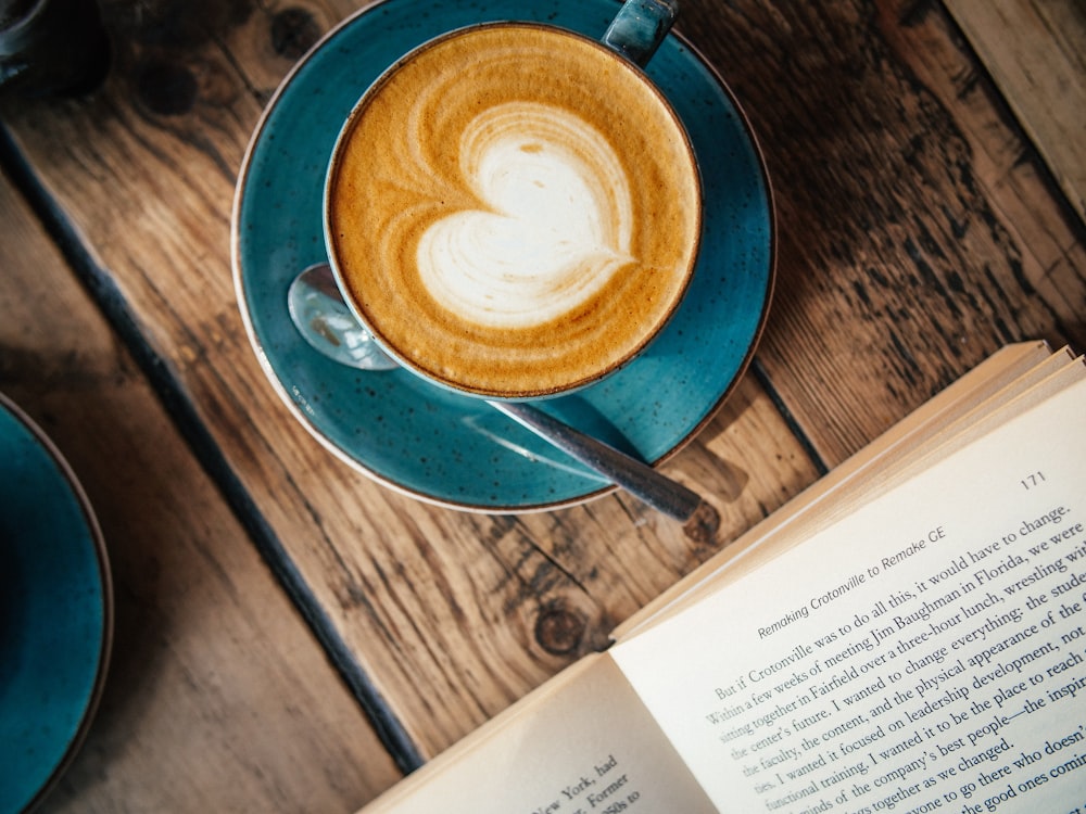 blue ceramic mug with cappuccino on blue saucer