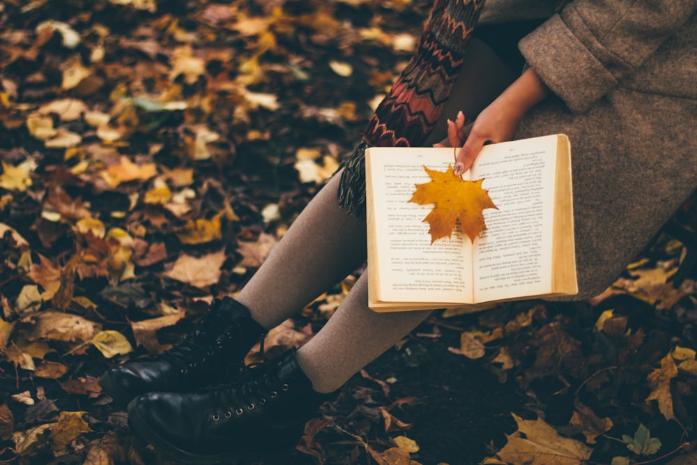 person holding yellow maple leaf