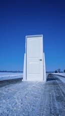 white wooden door near body of water during daytime