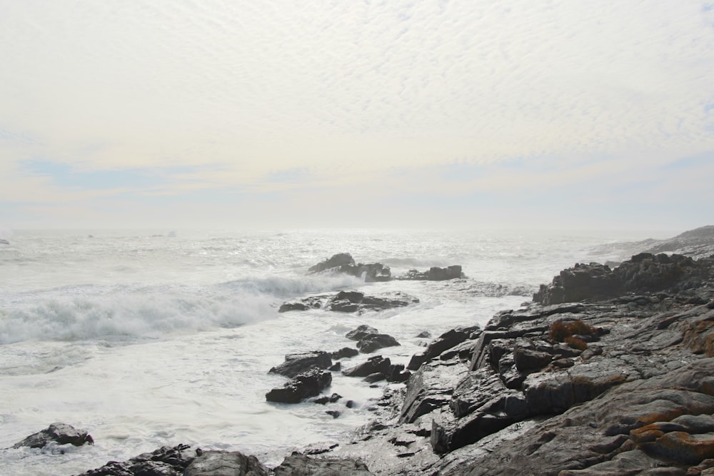 black rock formation on sea during daytime