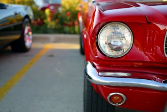 A close-up of a shiny used car ready for export, parked in a lot with shipping containers in the background.
