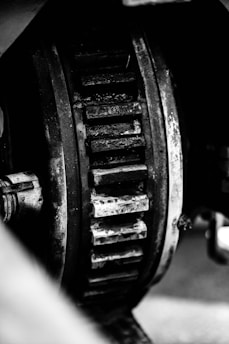 Large industrial machine gears coated with thick lubricant in a factory setting.