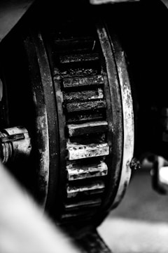 A close-up view of a large, heavy-duty gear with visible wear and grime, indicating industrial use and age.