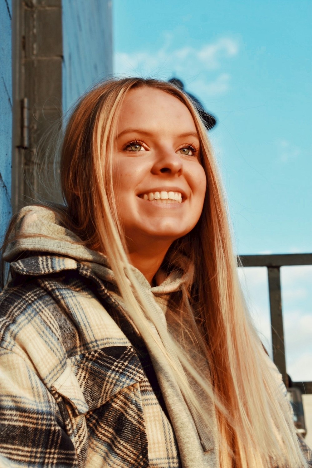 woman in black and white plaid shirt smiling