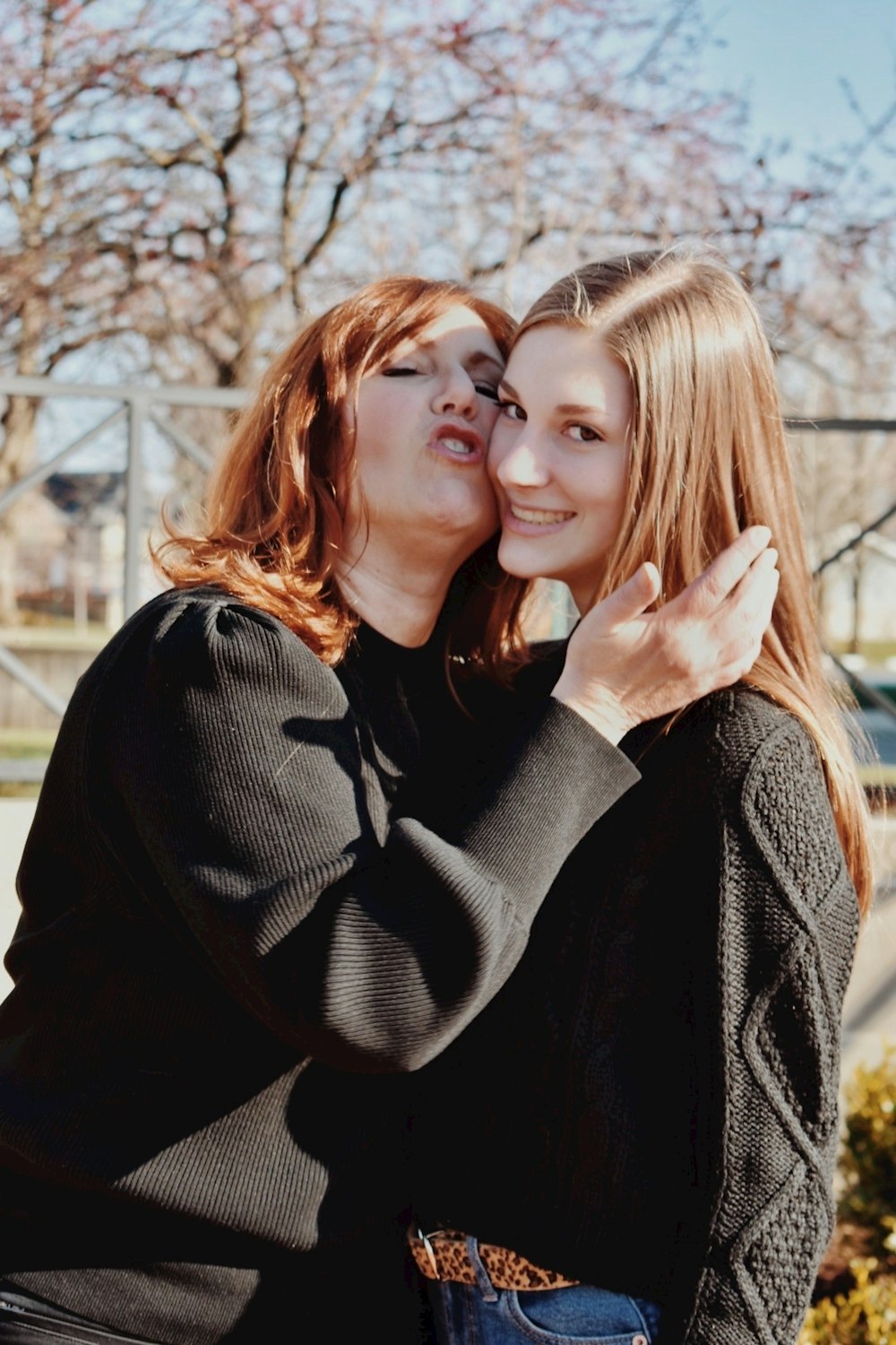 woman in black sweater hugging woman in gray sweater