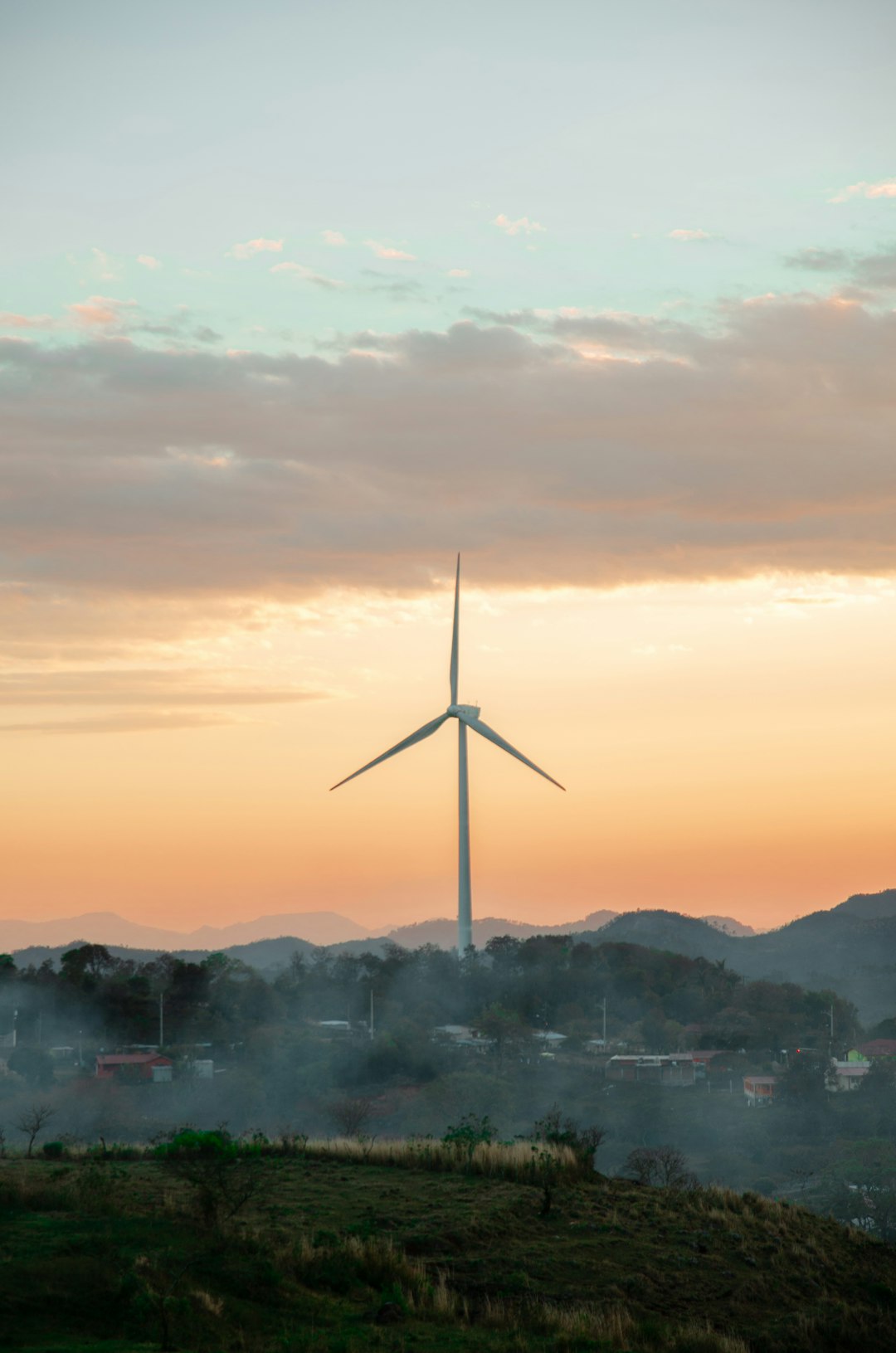 wind turbine on a hill during sunset