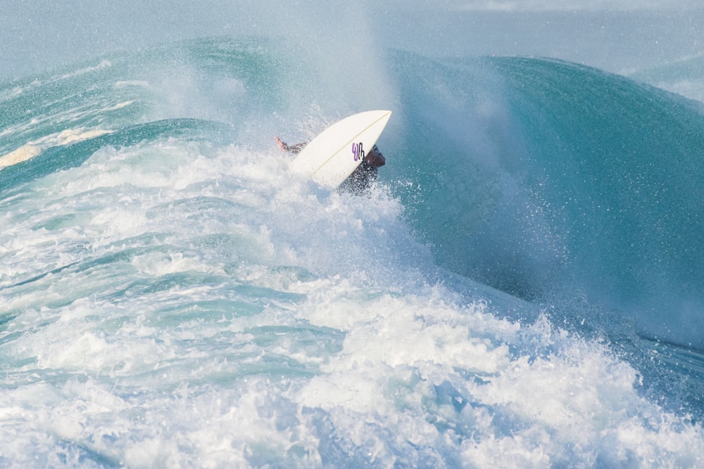 man surfing on sea waves during daytime