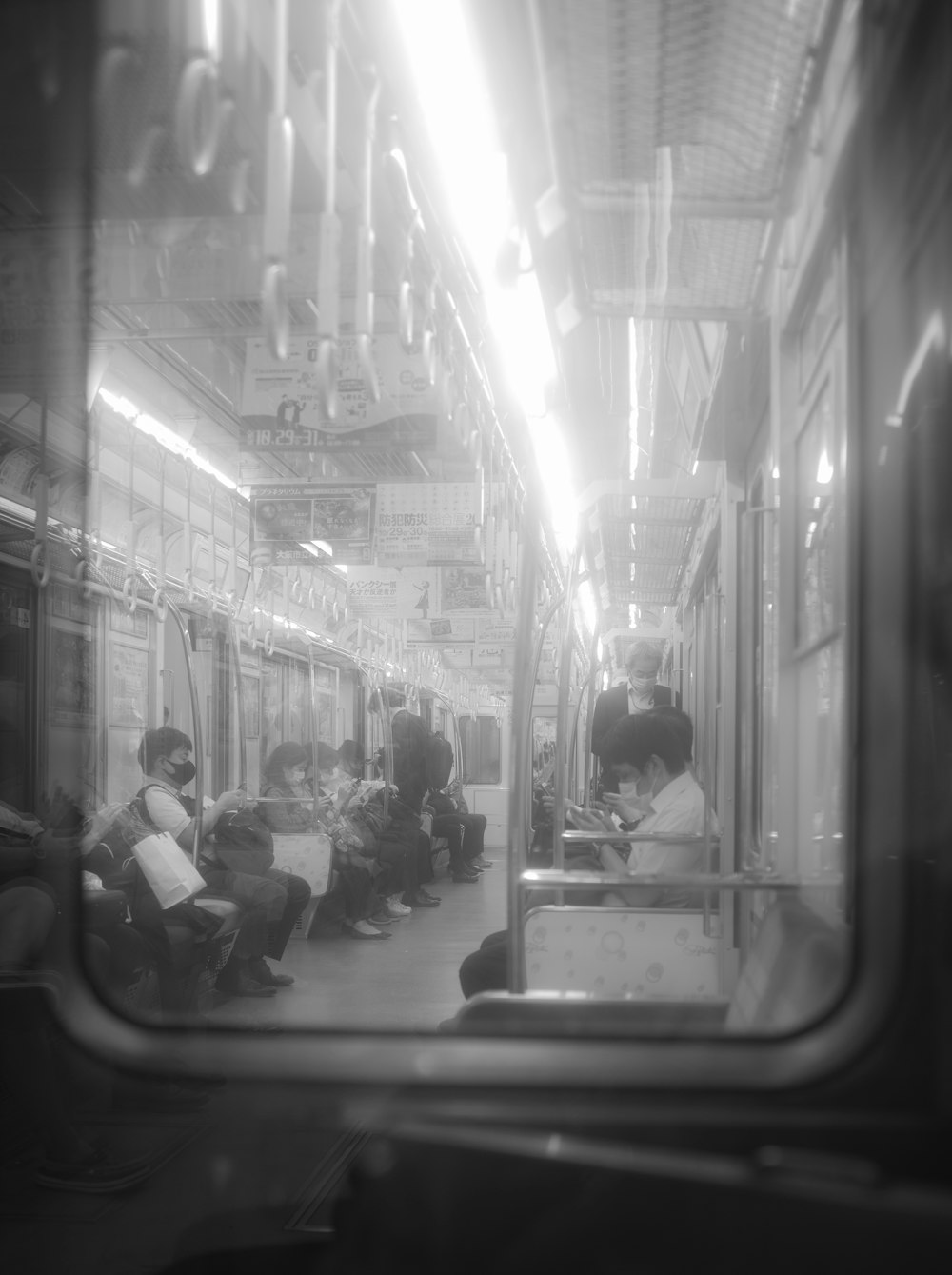 people sitting on train station in grayscale photography