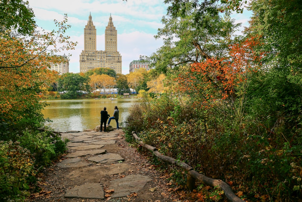 people walking on pathway near body of water during daytime