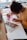 A person engrossed in painting with watercolors, using a vibrant palette and brush to create floral designs on paper. The workspace is filled with artistic tools and materials, creating a creative atmosphere.