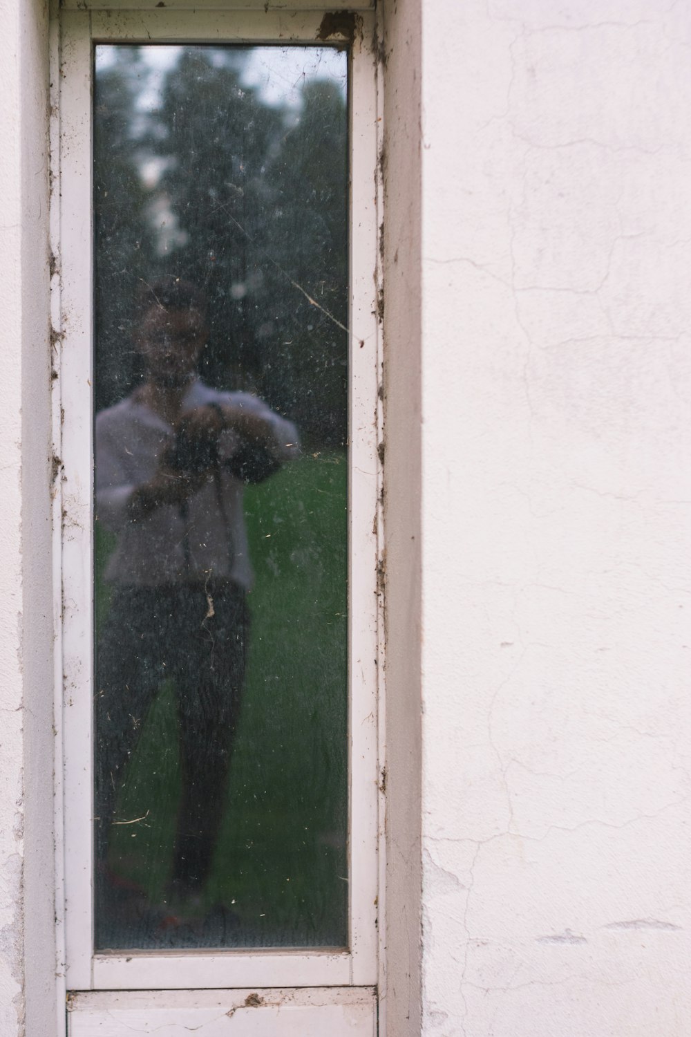 man in black jacket standing in front of glass window
