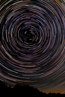 A time-lapse photo capturing star trails circling the North Star.