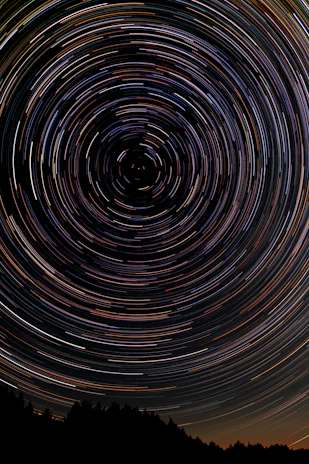 A time-lapse photo capturing star trails circling the North Star.