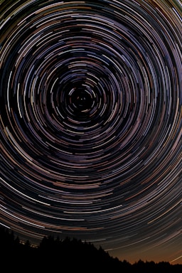 golden ratio for photo composition,how to photograph long exposure star trails centered on north star with trees silhouetted in foreground. ; black and white spiral illustration