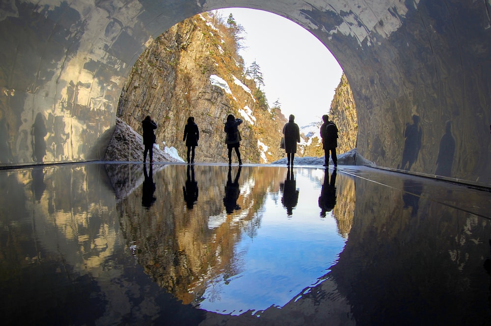 people standing on arch shaped tunnel during daytime