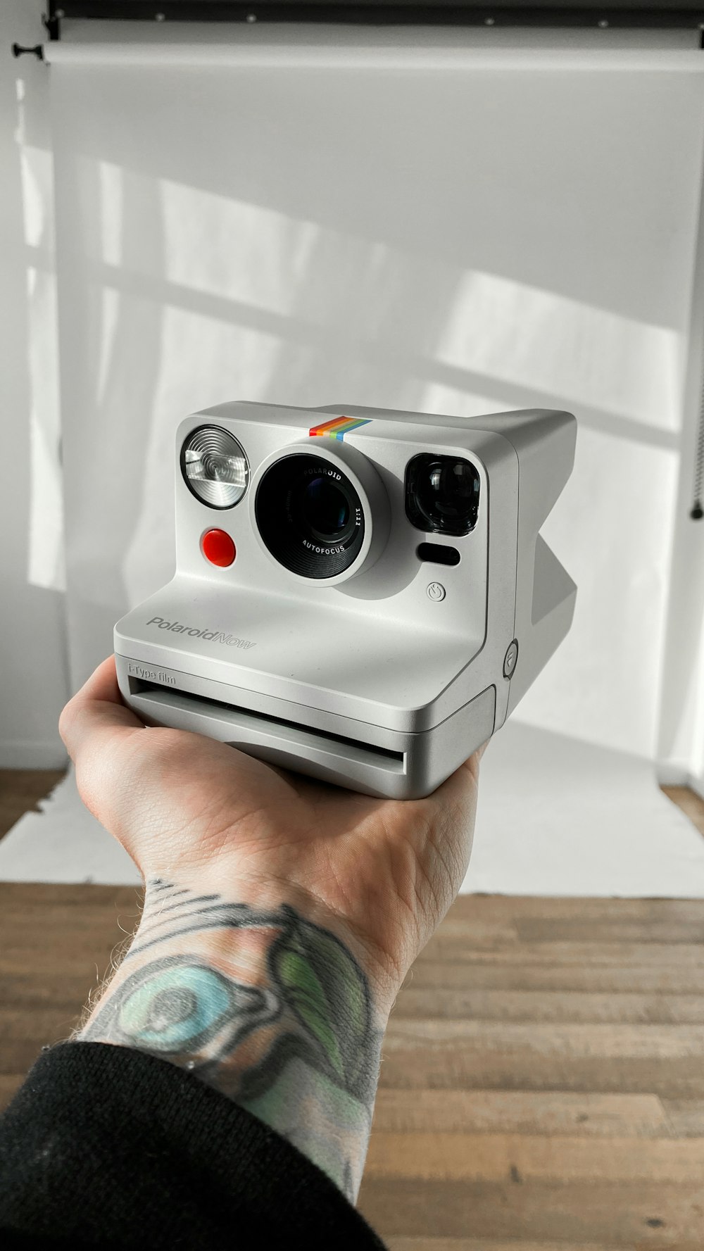 person holding black and white polaroid camera