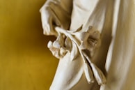 A close-up of a delicate sculpture being carefully handled.
