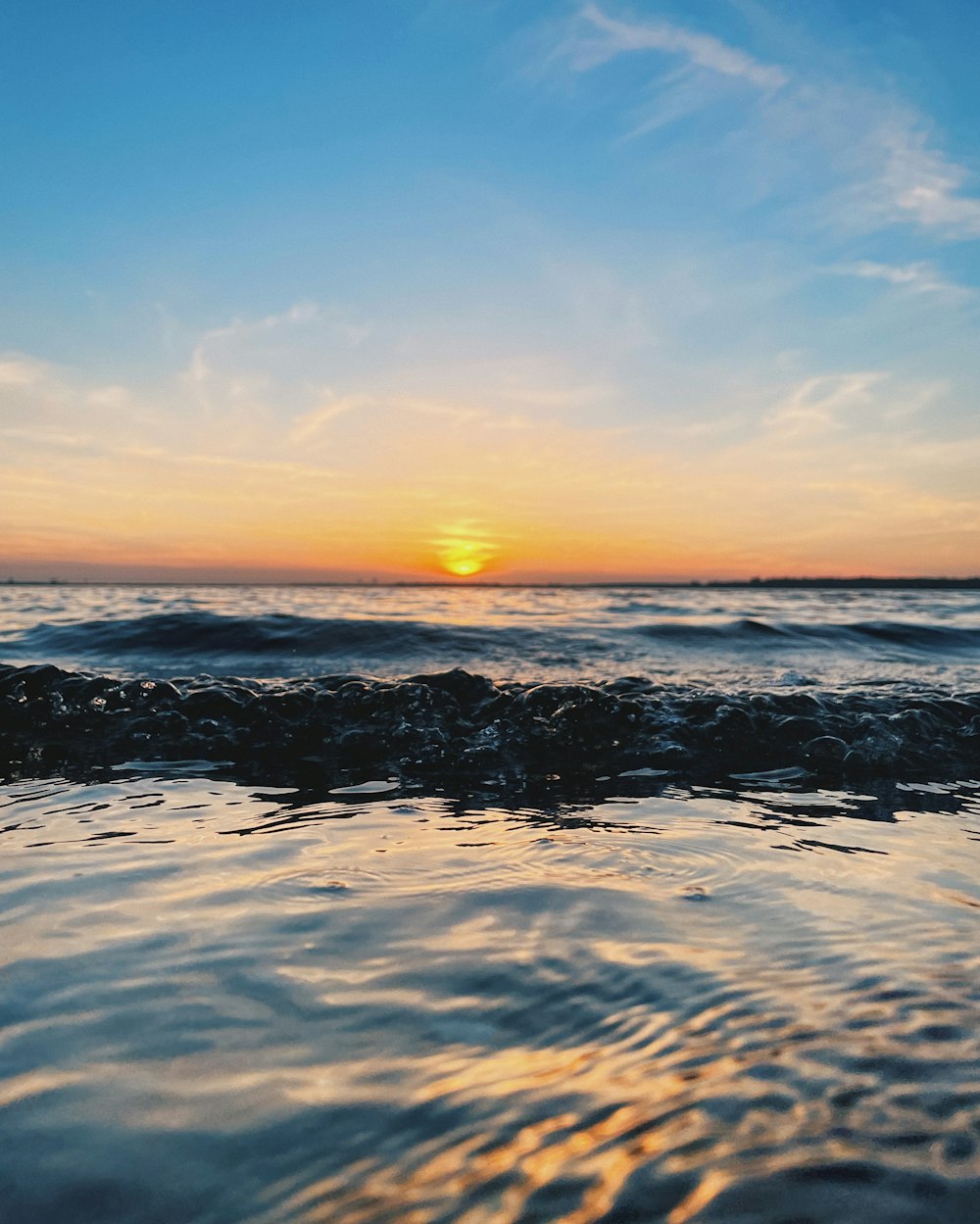 ocean waves crashing on shore during sunset