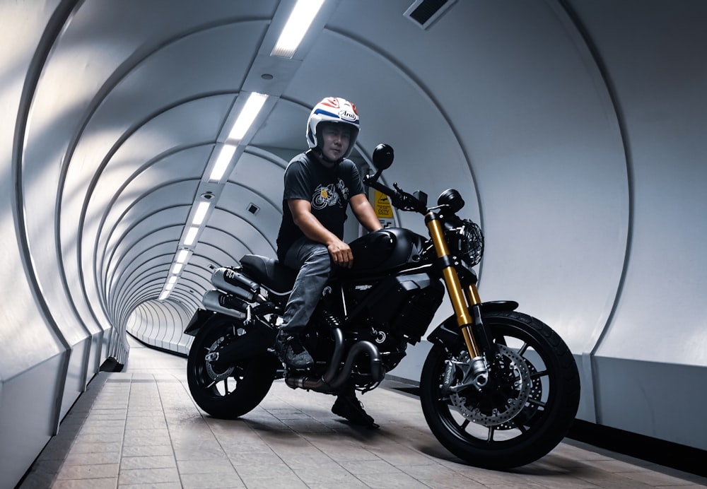 man in black helmet riding black motorcycle