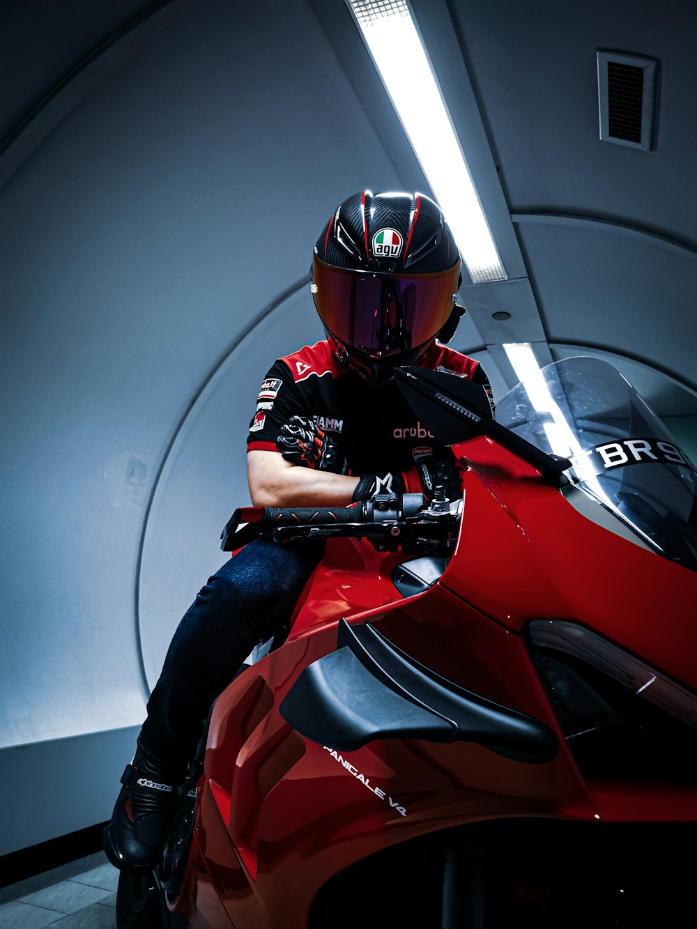 赤いスポーツバイクに乗る黒いヘルメットの男