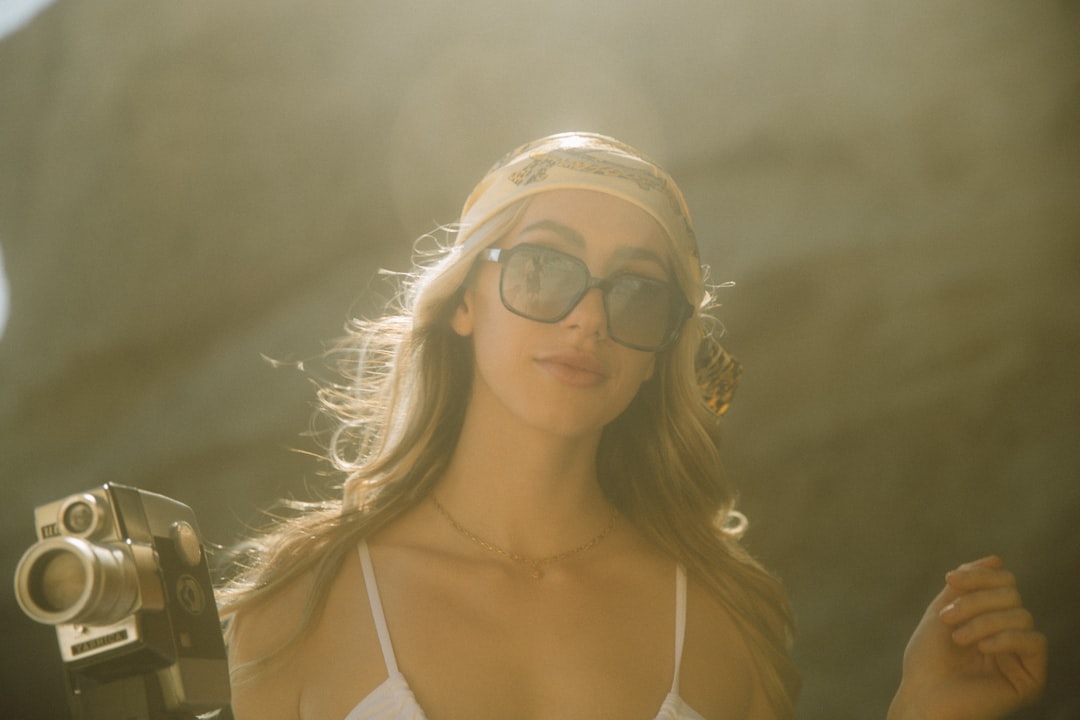 woman in white spaghetti strap top wearing aviator sunglasses