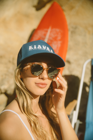 woman in black and blue fitted cap and black sunglasses