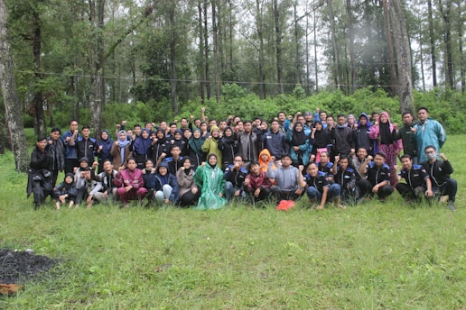 A warm group photo of Federal Government College Wukari Class of 1997 alumni reunited outdoors, smiling and sharing stories.