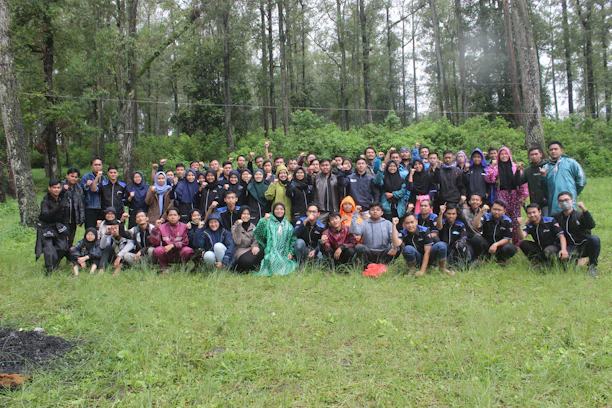 A warm group photo of the team collaborating outdoors with local community members.