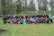 Group photo of alumni gathered joyfully at the Oak Jubilee event with school banners.