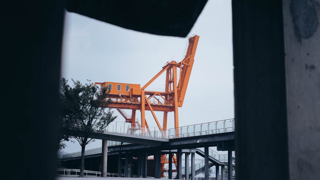 orange and black crane near building during daytime