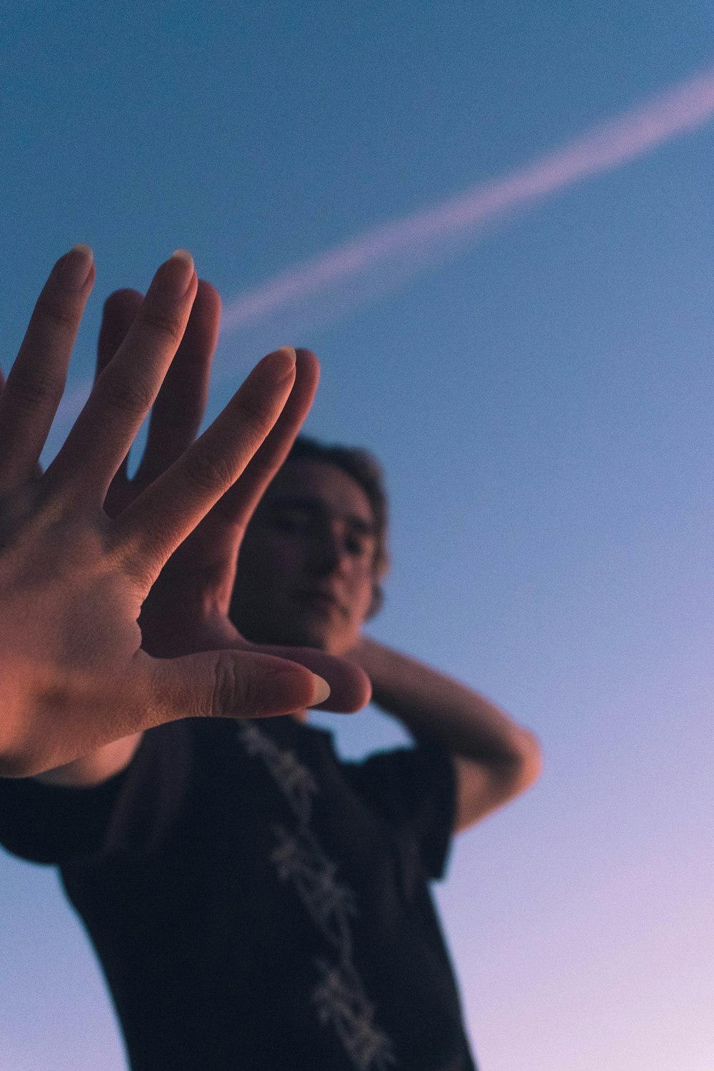 silhouette of person raising right hand